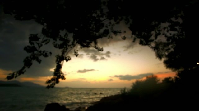 Sunset on a wild beach in Thailand. Blurred background