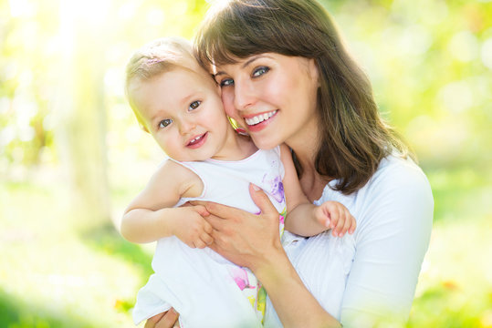 Beautiful mother and baby playing in a park