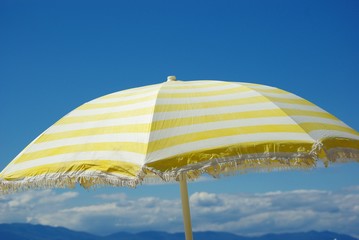 Gelber Sonnenschirm vor blauem Himmel