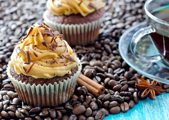 A cup of coffee and a muffin with coffee beans background