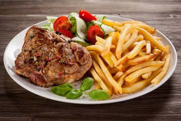 Grilled steak, French fries and vegetables