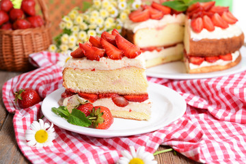 Delicious biscuit cake with strawberries on table close-up