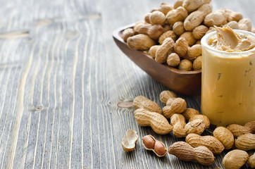 Peanut butter in a glass and peanuts copy space
