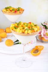 Fototapeta na wymiar Apricot dessert in glasses on table on bright background