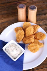 Chicken nuggets with sauce on table close-up