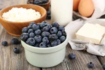 Fresh blueberries and milk products on wooden table