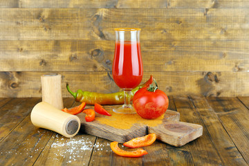 glass of tasty tomato juice and  pepper on wooden table