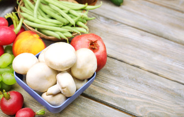 Fresh organic vegetables and fruits on wooden background
