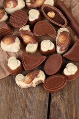 Different kinds of chocolates on wooden table close-up