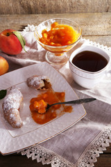 still life with cup of tea and apricot jam on wooden table