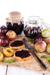 Plum jam, slices of bread with plum jam and fresh plums in