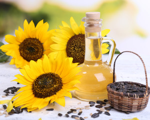 Obraz na płótnie Canvas Sunflowers with seeds and oil on table close-up