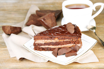 Chocolate cake on plate, on wooden background