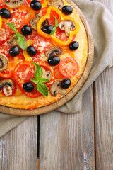 Delicious pizza served on wooden table