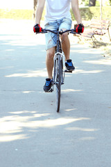 Young man riding bike in city park