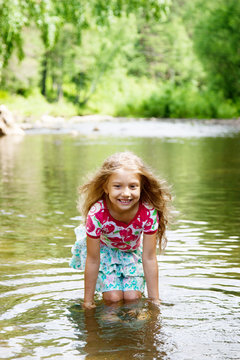 Adorable   girl  in   river on sunny   day