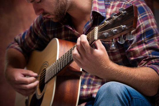 musician playing acoustic guitar