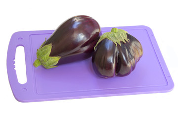 Eggplant on a plastic cutting board, white background