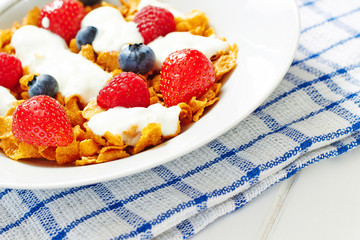 Corn flakes with yogurt and berries on plate