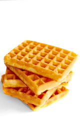 Golden waffles on vintage white wooden table with space