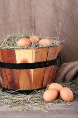 Big round basket with dried grass and fresh eggs
