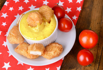 Chicken nuggets with sauce on table close-up