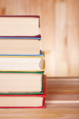 Books on wooden table on wooden wall background