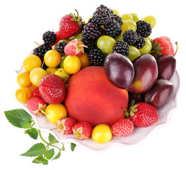 Different berries and fruits in plate isolated on white