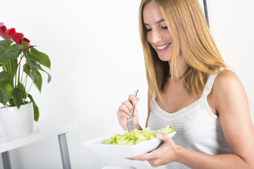 Obraz na płótnie Canvas Woman eating green salad