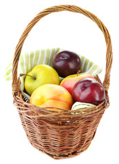 Assortment of juicy fruits in wicker basket, isolated on white