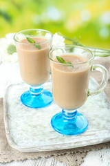 Delicious berry mousse in glasses on table on bright background