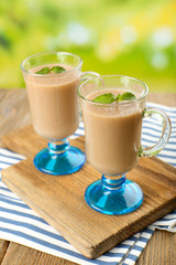 Delicious berry mousse in glasses on table on bright background