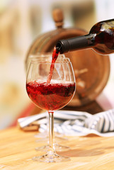 Red wine pouring into wine glass, close-up