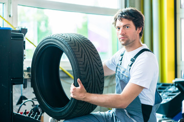 Mechaniker bei Reifenwechsel in Autowerkstatt