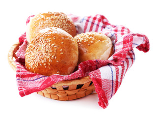 Tasty buns with sesame in wicker basket, isolated on white