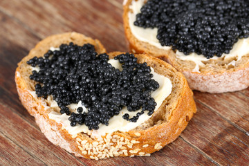 Slices of bread with butter and black caviar