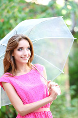 Beautiful young girl with umbrella outdoors