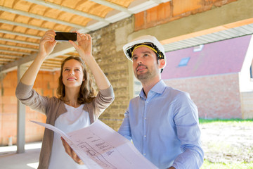 Young woman and architect on construction site