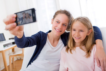 Attractive woman and little sister taking selfie