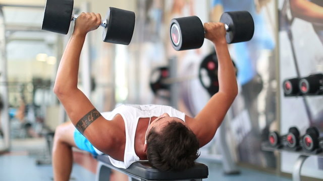 attractive young man exercising in the gym