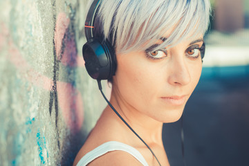 young beautiful short blue hair hipster woman with headphones mu