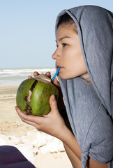 Fototapeta premium Beautiful woman drinking coconut juice