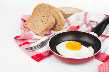 Fried egg in a frying pan, over white background