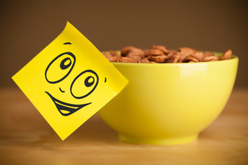 Post-it note with smiley face sticked on cereal bowl - Powered by Adobe