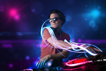 Disc jockey playing music with electro light effects and lights