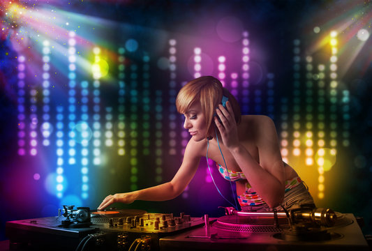 Dj girl playing songs in a disco with light show