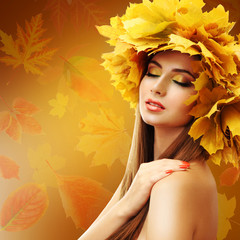 Beautiful young woman with yellow autumn wreath