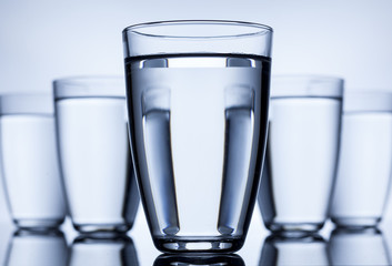 group of five full glasses with water