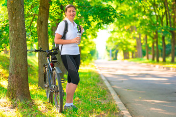 Fototapeta premium young girl resting in a park with a bicycle