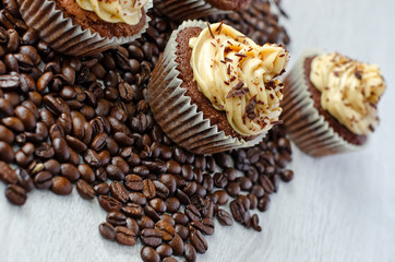 Chocolate muffins with caramel cream on coffee beans  background
